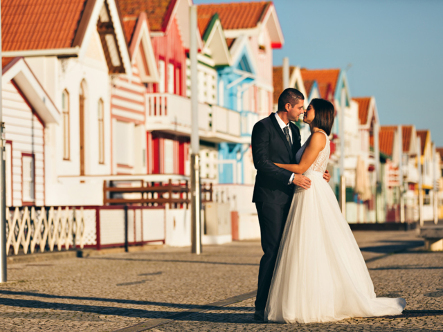 A newlywed couple in front of colourful houses - Wedding photography. 