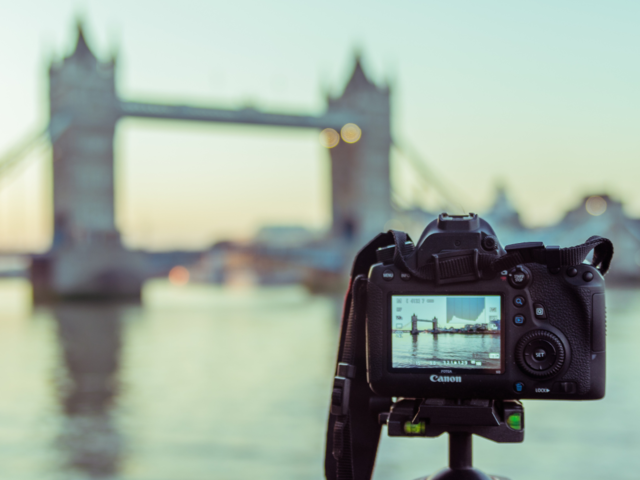 A camera on a tripod taking a photo of London Bridge