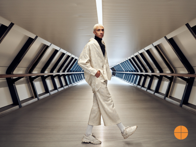 A man in a tunnel wearing light colour outfit - Fashion photography.